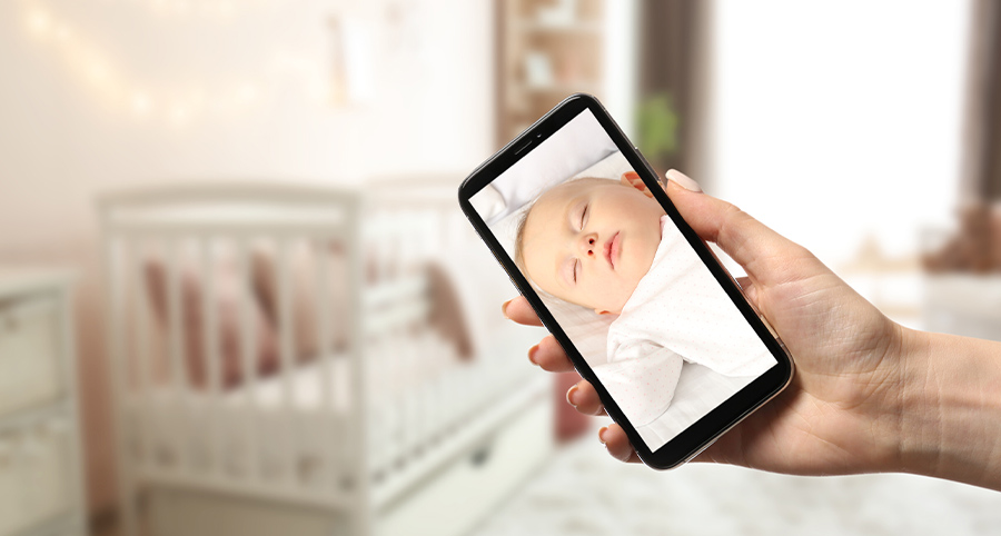 Parent using smartphone to view video of child from indoor camera